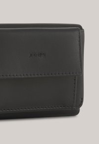 Cartera de cuero negro con bordes cosidos, que presenta un sutil logo embosado. Textura suave con forma rectangular y cierre a presión.