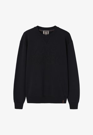 Laivastonsininen collegepaita kohokuvioisella kirjailulla, V-kaula-aukolla, resorihihoilla ja -helmalla. Alareunassa pieni ruskea merkki.