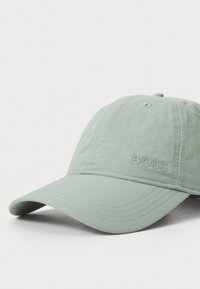 Mint green cap made of lightweight fabric, featuring a curved brim, stitched details, and embossed "BOSS" branding on the front.