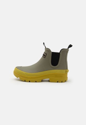 Botte de cheville imperméable en gris clair avec une semelle jaune, dotée d'un panneau élastique noir et d'une languette arrière pour un enfilage facile.