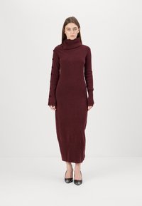 Burgunderfarbendes, langärmliges Strickkleid mit hochgeschlossenem Kragen, das über Knopfdetails an einem Ärmel und eine figurbetonte Silhouette verfügt. Glatte Textur.
