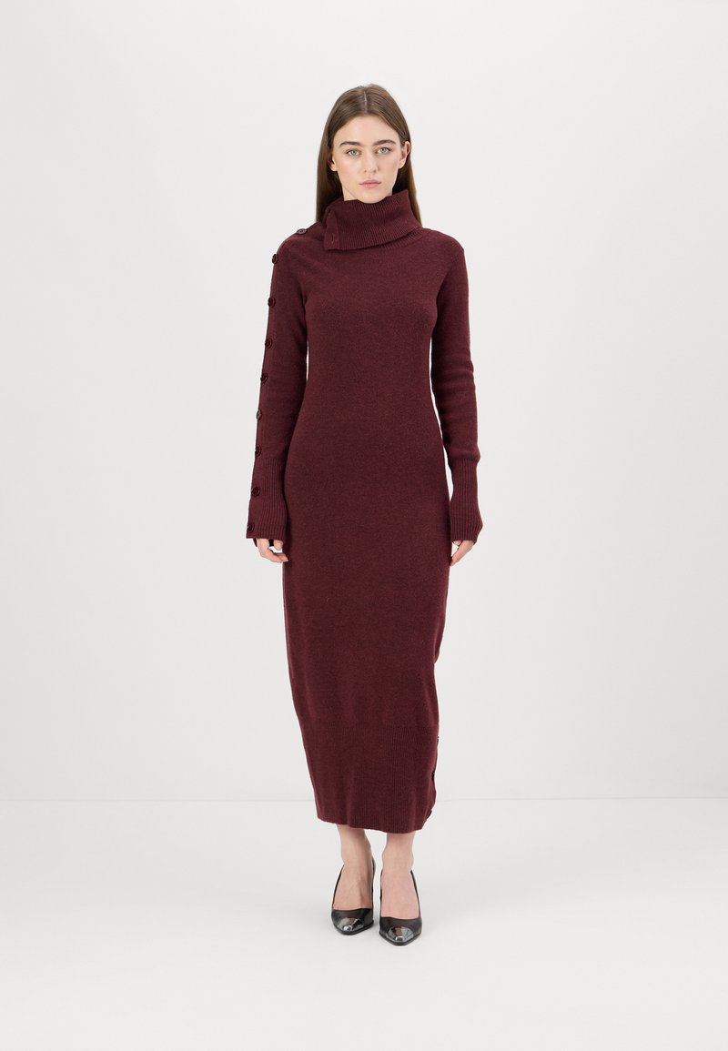 Burgunderfarbendes, langärmliges Strickkleid mit hochgeschlossenem Kragen, das über Knopfdetails an einem Ärmel und eine figurbetonte Silhouette verfügt. Glatte Textur.
