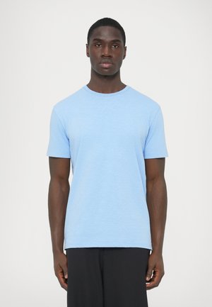 Modré bavlnené tričko s krátkymi rukávmi, okrúhlym výstrihom a mierne textúrovaným povrchom. Jednoduchý dizajn, rovný strih, v kombinácii s čiernymi nohavicami.