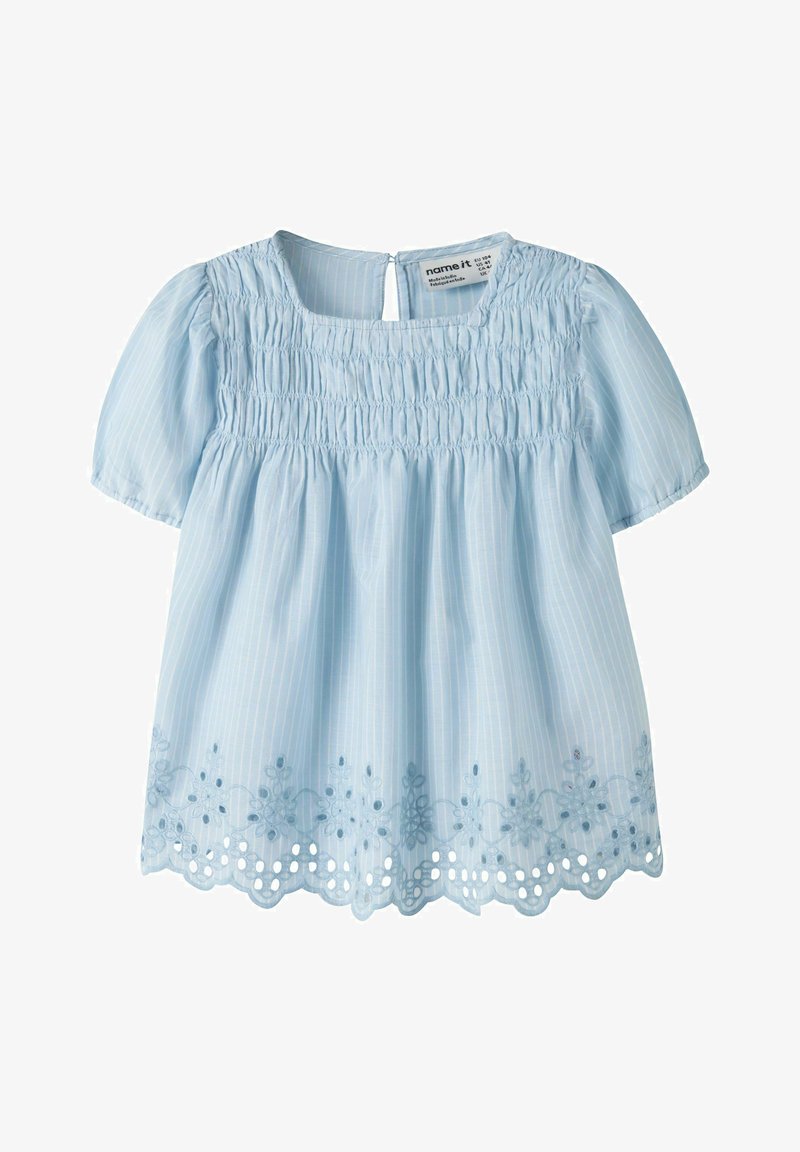 Blouse bleu clair à manches courtes avec corsage smocké, fines rayures verticales, dos avec ouverture en forme de goutte et broderie florale festonnée au bas.