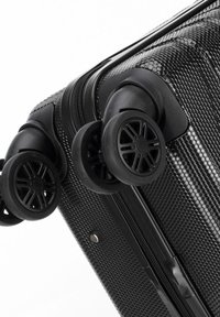 Zwarte koffer op wielen met een gestructureerd hexagonaal patroon, soepele ritssluitingen en duurzame kunststof wielen. Voorzien van stevige handgrepen aan de zijkant.