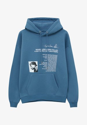 Blauer Hoodie mit Fronttasche mit weißem Text „When Ure Hero Falls: 4 My Hero (My Mother)“ und einem schwarz-weißen Profilfoto eines Mannes mit Kappe.