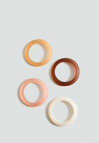 Quattro anelli in silicone di vari colori: arancione chiaro, pesca, marrone e avorio. Texture liscia e forma circolare.