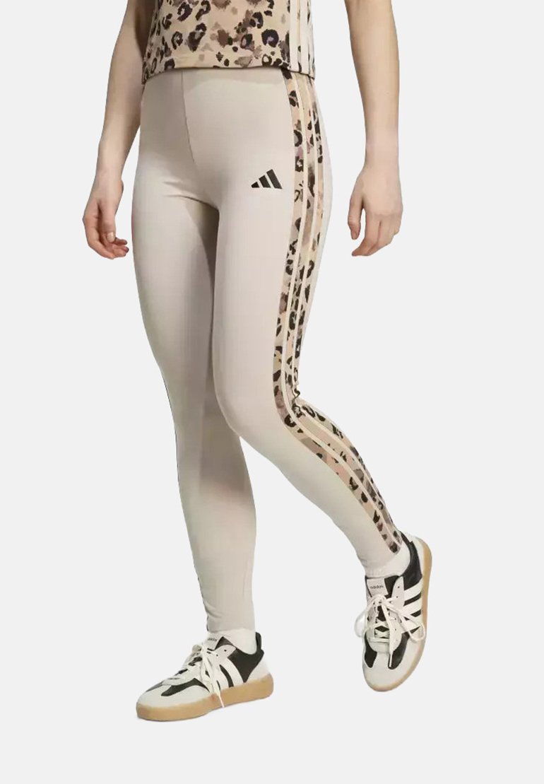 Leggings beige con un pannello laterale a stampa leopardo e un design a tre strisce. Realizzati in materiale elastico, presentano una forma aderente e una leggera lucentezza.