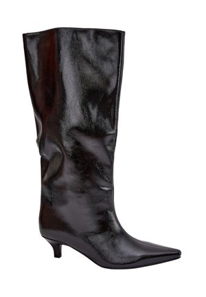 Botte noire en cuir brillant, montante jusqu'au genou, avec un bout pointu et un petit talon, inclinée vers la droite sur fond blanc.