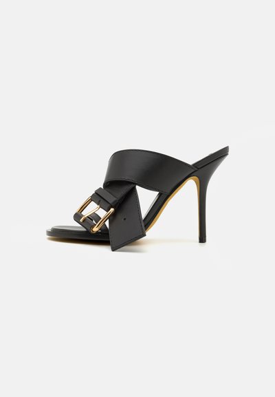 Black high-heeled mules with a smooth leather upper, featuring a wide strap and a gold-tone buckle detail on the front.