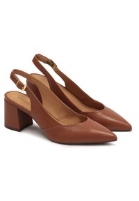 Scarpe slingback in pelle marrone con punta a forma di bottone, tacco medio a blocco e dettagli in hardware tono oro. Texture liscia e design minimalista.