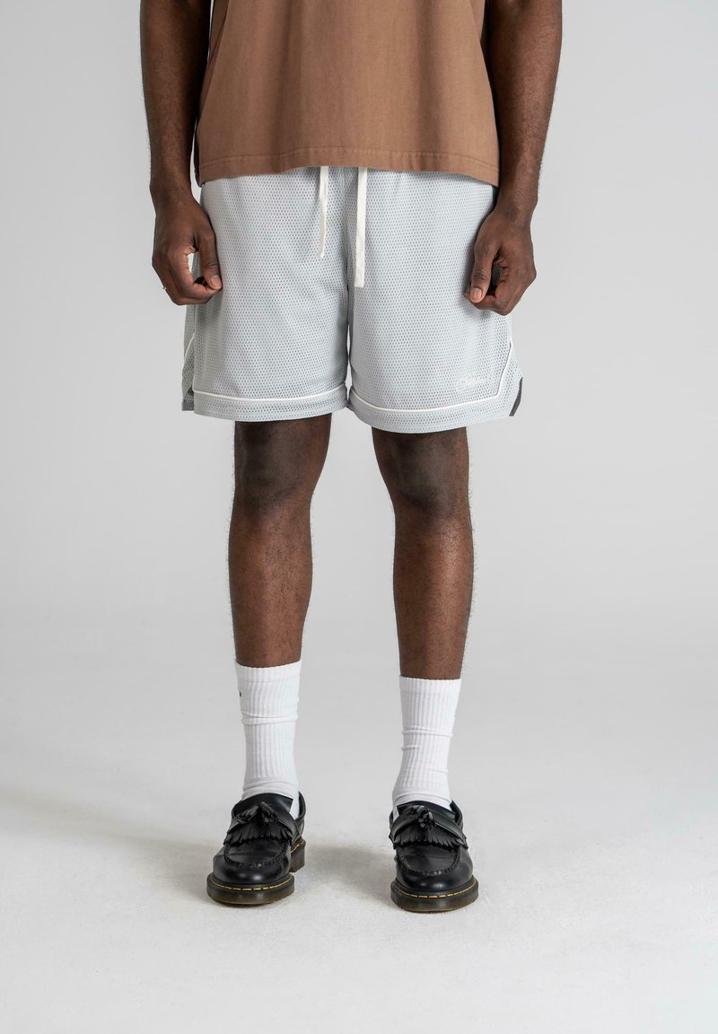 Light gray mesh shorts with a loose fit, white drawstring, and contrasting trim, paired with black decorative loafers and white socks.