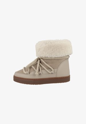 Botas de tobillo beige con un suave puño de piel de pelo, con un acabado de cuero texturizado y ante, y gruesos cordones beige sobre una suela de goma.
