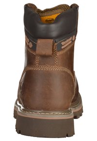 Bota de trabajo de cuero marrón con un collar acolchado negro, una lengüeta en la parte trasera y una suela robusta con tracción. Presenta detalles de costura en contraste.