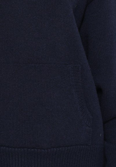 Navy blue knitted sweater featuring a front pocket, ribbed cuffs and hem, and a textured finish. The fabric appears soft and warm.