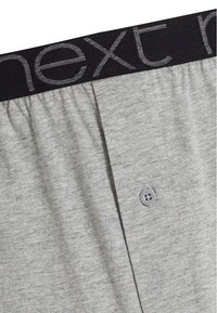 Grå bomullsherrens boxershorts med svart elastiskt midjeband som har "next" i grå bokstäver och en enda knäppning framtill.