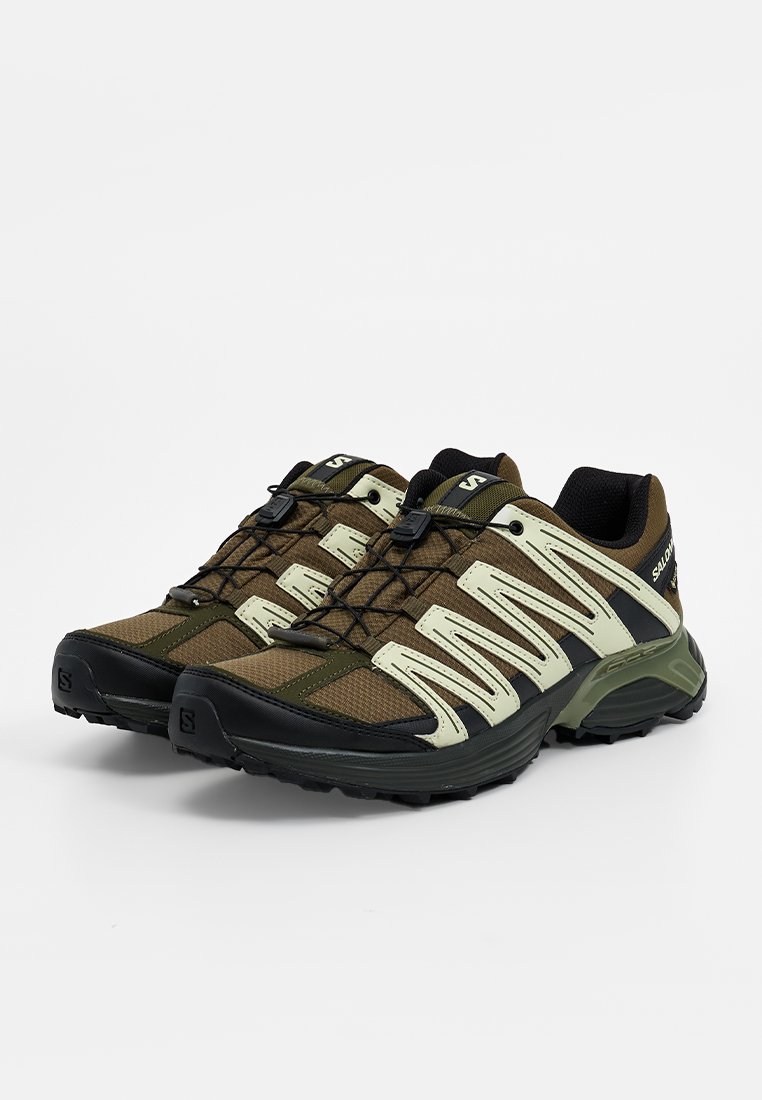 Buty trailowe z brązową i oliwkową siateczką, czarnymi gumowymi akcentami i teksturowanymi podeszwami. Model na sznurówki z elementami odblaskowymi.