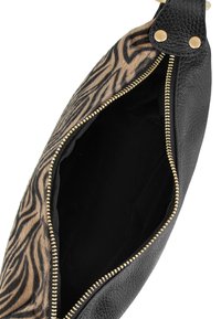 Borsa a tracolla in pelle nera con una pattina a stampa zebra, dotata di chiusura con zip dorata e interno nero. La borsa presenta dettagli metallici sulla tracolla.