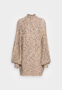 Gestrickter Pullover in sanftem Beige mit Textur und geometrischem Muster. Hoher Kragen, übergroße Ärmel und gerippte Saumdetails.