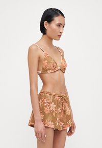 Bikini floral marron avec un haut triangle et des bretelles réglables, associé à un short taille haute assorti avec une taille à cordon.