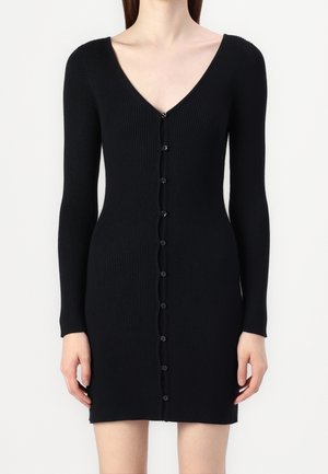 Schwarzes langärmliges Kleid aus Rippenstrick mit tiefem V-Ausschnitt und Knopfleiste vorne, figurbetonte Silhouette, endet über den Knien.
