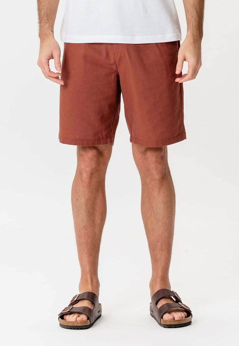 Herrernes rustfarvede shorts lavet af bomuld, med lige skæring og opslåede kanter, parret med brune justerbare sandaler.