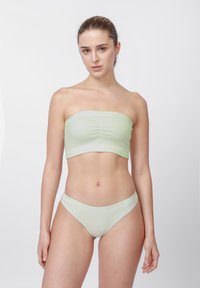 Világoszöld bordázott bandeau felső és hozzá illő bugyi, középen összehúzott és varrás nélküli szegéllyel. Puha, sima tapintású anyag.