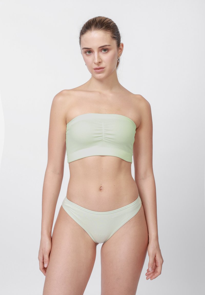 Világoszöld bordázott bandeau felső és hozzá illő bugyi, középen összehúzott és varrás nélküli szegéllyel. Puha, sima tapintású anyag.