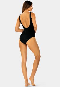 Czarny jednoczęściowy strój kąpielowy z niskim fasonem pleców, regulowanymi ramiączkami i gładką teksturą. Uformowany z medium wyciętymi nogawkami i minimalistycznym wyglądem.