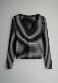 Melnas un baltas svītrains garām piedurknēm tops ar V veida kakla un ribotu tekstūru. Audums šķiet mīksts un elastīgs, ideāli piemērots ikdienas valkāšanai.