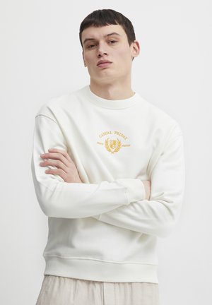 Sudadera blanca con cuello redondo acanalado, mangas con puños y un logo bordado "CASUAL FRIDAY" en dorado en el pecho. Textura suave.