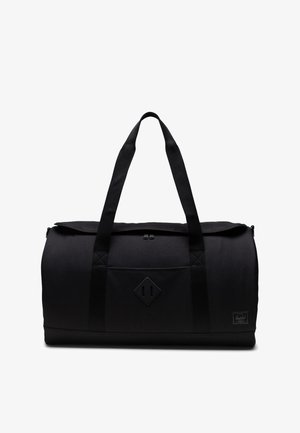 Sac de sport noir en forme arrondie, en matériau textile, avec deux poignées supérieures, fermeture zippée et une poche avant avec un écusson en forme de diamant.