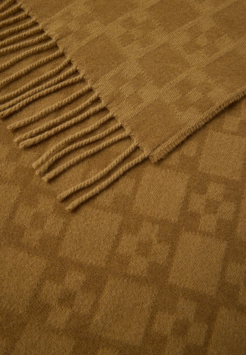 Brown woven scarf with a subtle checkered pattern, featuring long fringes on one edge and a soft, textured finish.