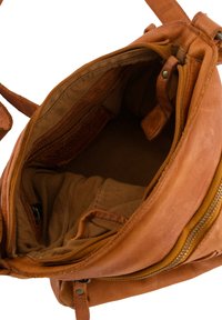 Sac à main en cuir, couleur tan, ouverture zippée, texture douce, poche intérieure, doublure en coton, couture renforcée, design compacte.