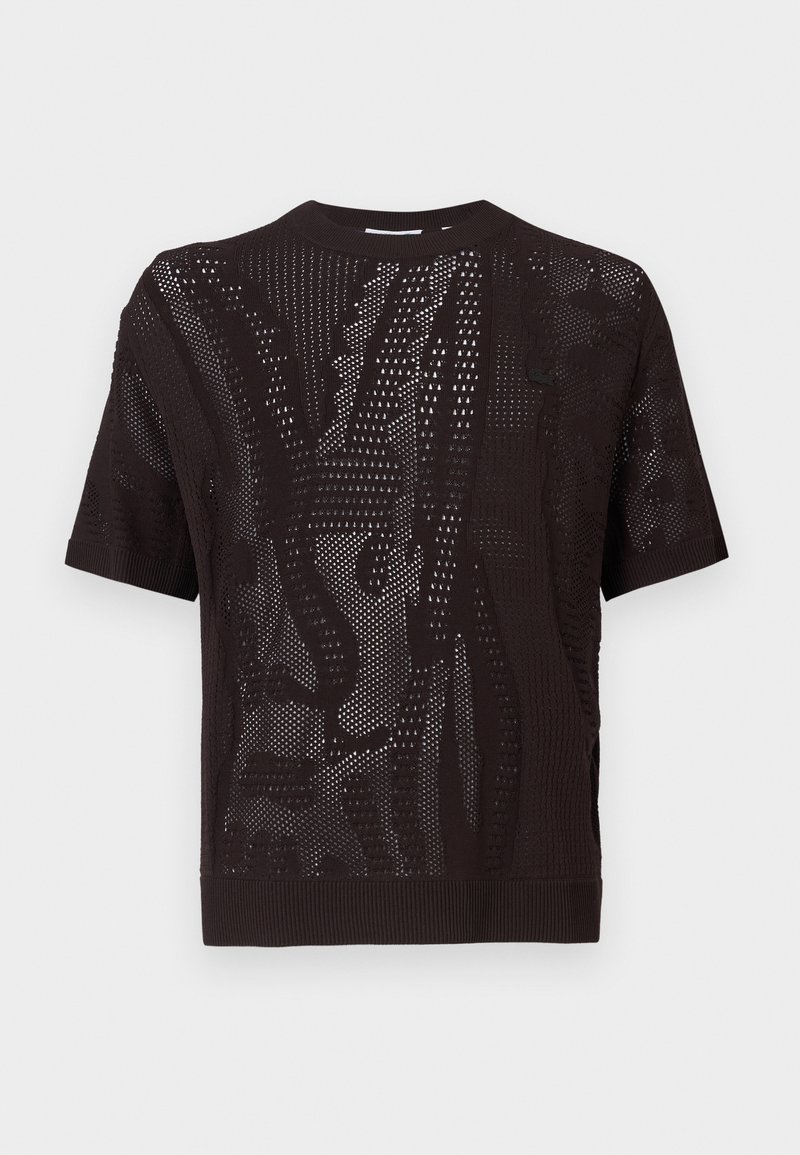 Haut noir à manches courtes avec un motif tricoté texturé, des détails perforés et un ourlet côtelé. Le matériau semble léger et respirant.