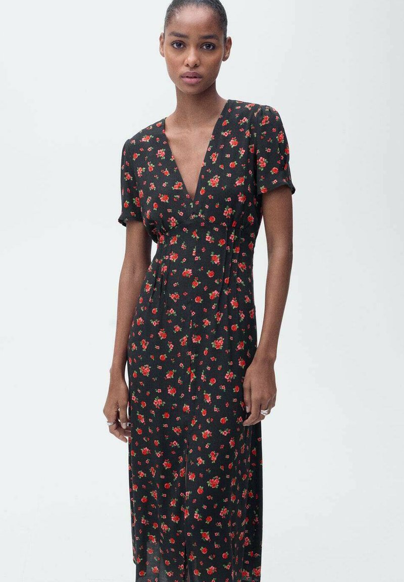 Schwarzes Blumenkleid mit V-Ausschnitt, kurzen Ärmeln und fließender Silhouette, das überall im Stoff kleine rote und grüne Blumen aufweist.
