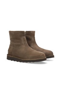 Botines de ante marrón con punta redondeada, parte superior sin costuras y suela texturizada, con un pequeño acento de logo en la parte trasera.