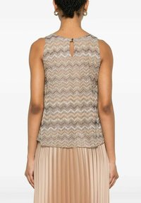 Top senza maniche beige con un motivo a zigzag e un leggero luccichio, caratterizzato da un dettaglio a chiave sul retro e una silhouette aderente.