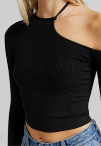 Svart ribbad långärmad crop top med asymmetrisk halsringning, ett axelsnitt och en åtsittande passform. Tyget har en mjuk yta.