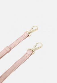 Correia de pele rosa com clipes em metal dourado, apresentando textura suave e um simples detalhe de costura. Logótipo gravado no clipe.