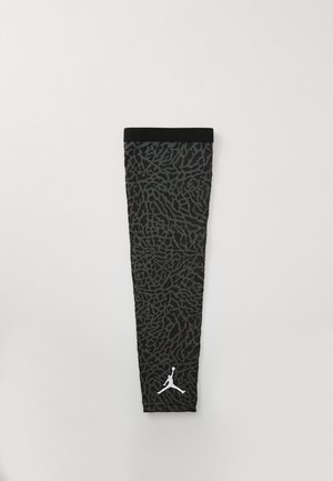 Μαύρη κάλτσα με μανίκι και υφή γκρι σχέδιο που παραπέμπει σε ζωικά μοτίβα. Διαθέτει μαύρη κορυφή και λευκό λογότυπο Jordan στη χαμηλότερη άκρη.