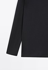 Sort langærmet skjorte lavet af glat stof. Har et enkelt design med rund hals og lige kant. Blød tekstur, ingen synlige mønstre.