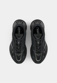 Black athletic shoes featuring a mesh upper, textured accents, and a thick sole with blue highlights and laces for secure fit.