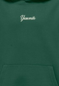 Zeleni pamučni dukserica s prednjim džepom i tekstom "Yosemite" u kremastom kurzivnom pismu na prednjem dijelu. Glatka tekstura i ležeran dizajn.