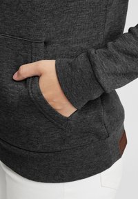Felpa grigia scura in cotone con tasca frontale, polsini a coste e finitura testurizzata. Etichetta in pelle applicata all'orlo.