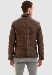 Bruine leren pufferjack met gestikte naden, een kraag en knoopmanchetten. Textuurafwerking, slim fit ontwerp en middelhoge snit.