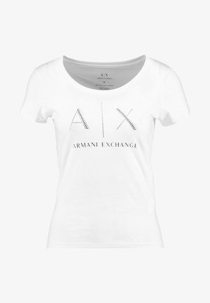 T-shirt en coton blanc avec un col rond et des manches courtes, présente "AIX" en strass argentés au-dessus de "ARMANI EXCHANGE" en texte noir.
