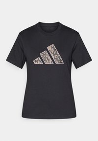 Črna bombažna majica s kratkimi rokavi, ki prikazuje velik leopardji potisk logotipa Adidas v zatišnih tonih ter ima okroglo ovratnico.