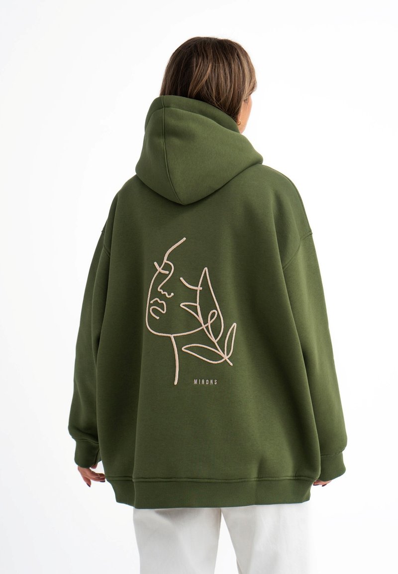 Groene oversized hoodie met een capuchon, met een minimalistische lijntekening van een gezicht en bladeren in beige op de achterkant. Gemaakt van een katoenmix.