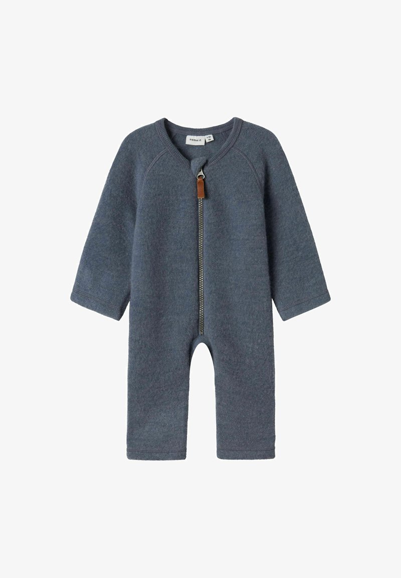 Siv volnen mešanici jumpsuit z dolgimi rokavi, sprednjim zadrgo in usnjeno zanko. Ima okrogel izrez in odprt design nog.